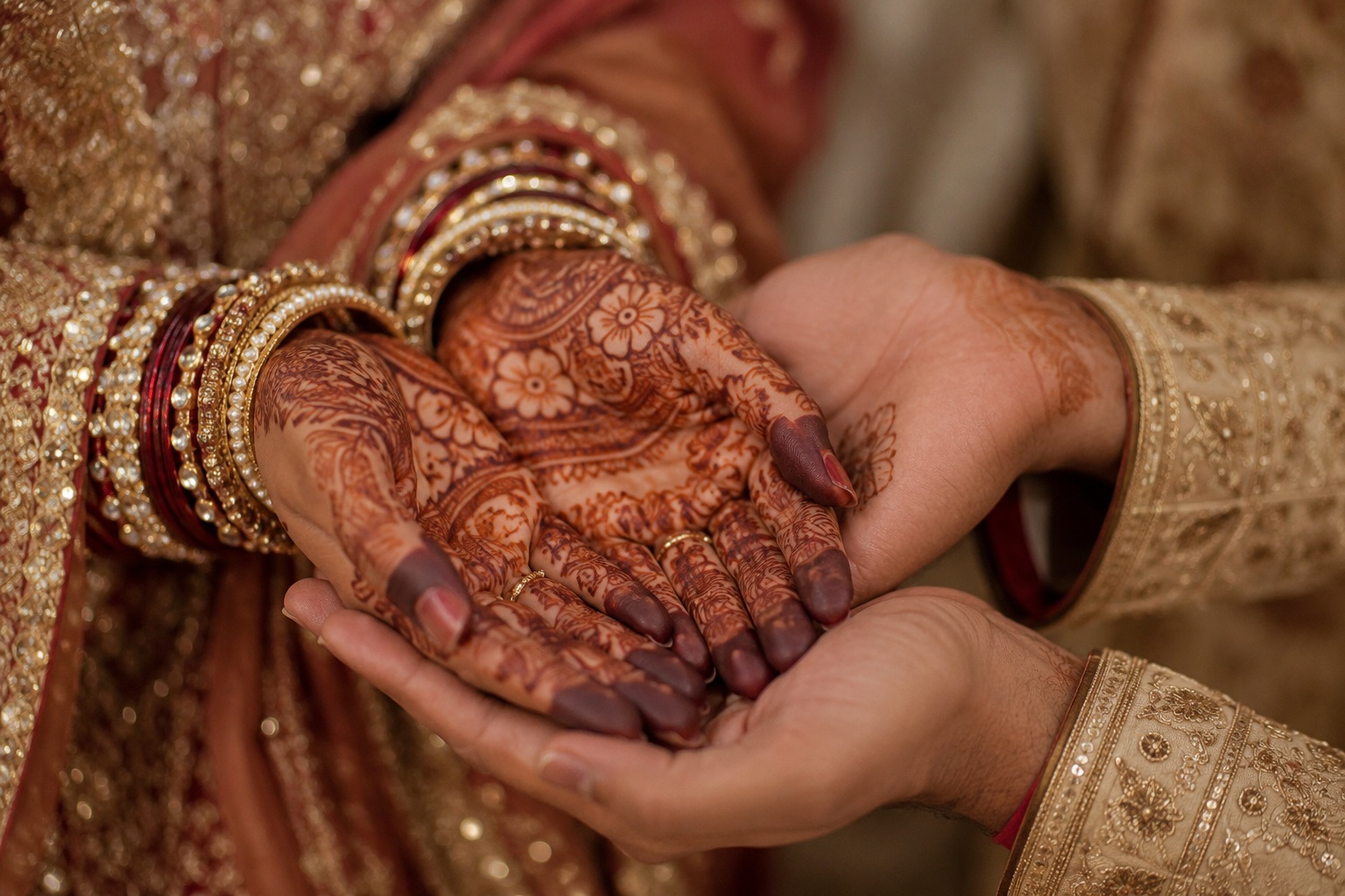 Bride and groom hands with mehendi and candle
